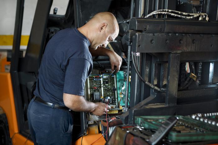 Mechanic servicing forklift