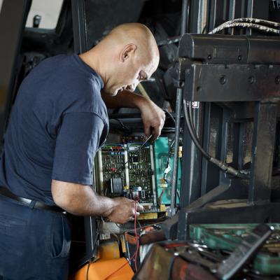 Mechanic servicing forklift